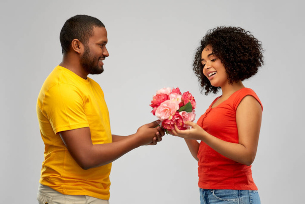 happy african american couple with flowers - Foto, Imagen
