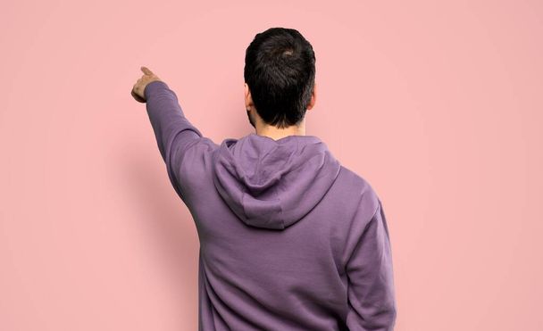 Przystojny mężczyzna w bluzie na odizolowanym różowym tle - Zdjęcie, obraz