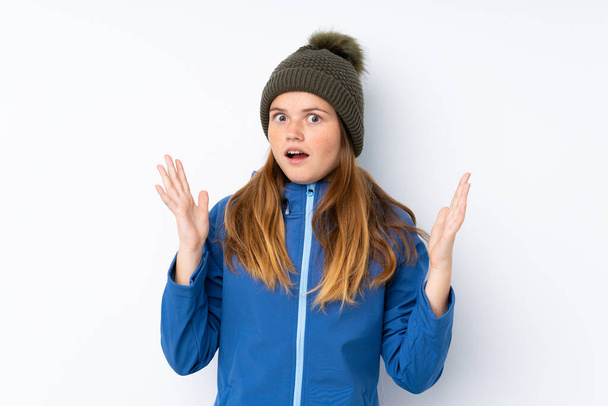 Ukrainian teenager girl with winter hat over isolated white background with surprise facial expression - Photo, Image