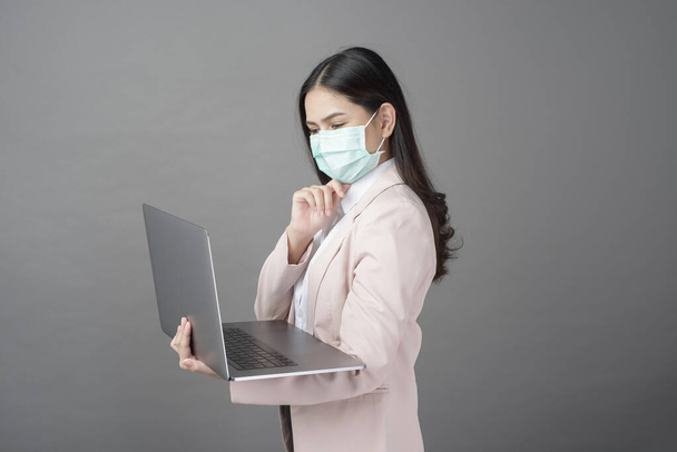 business woman with surgical mask is holding laptop computer  - Fotografie, Obrázek