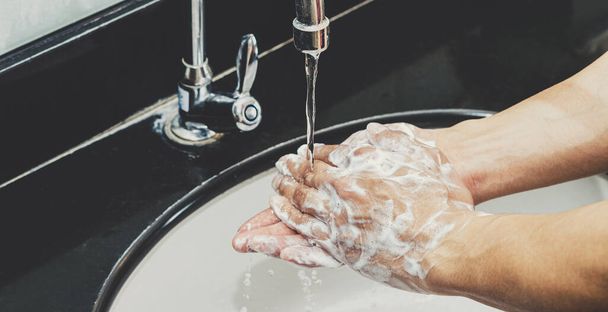 Lavarse las manos de cerca con grifo de cromo y jabón para la prevención de pandemias de Coronavirus en el baño, limpieza de responsabilidad personal, concepto de protección contra el virus de la corona de higiene de manos
 - Foto, Imagen