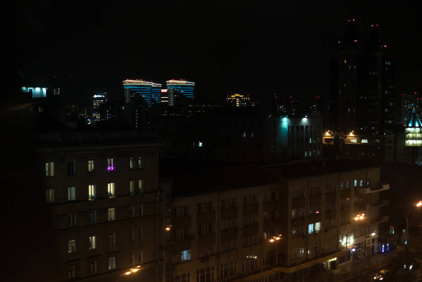 Novosibirsk, Russia - March 24, 2020. Nice view and panorama of the night big city and the capital, with illumination, black sky and light from lanterns and windows. - Foto, imagen