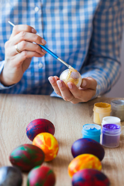 Holidays, handmade and creation concept - Girl draws on Easter egg, close-up. - Φωτογραφία, εικόνα