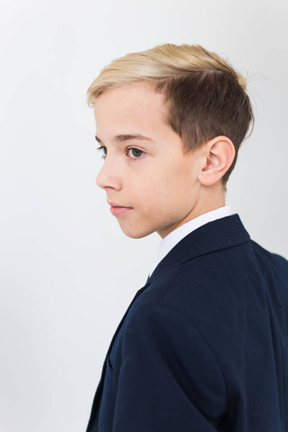 Portrait of stylish school boy teenager in white shirt and jacket against white background. - Photo, Image