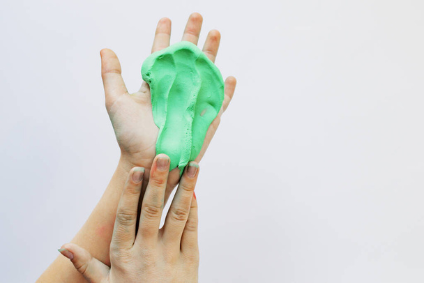 Children's hands play with a sticky mass of green color - Fotó, kép