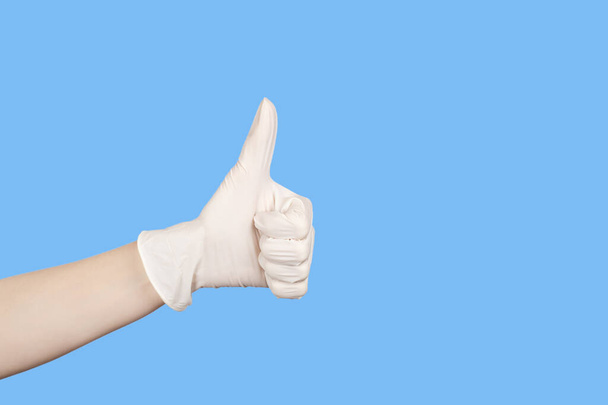 Ręczny gest. Ręka w białej rękawicy lateksowej pokazujące kciuki do góry znak izolowany na białym tle. Przestrzeń kopiowania - Zdjęcie, obraz