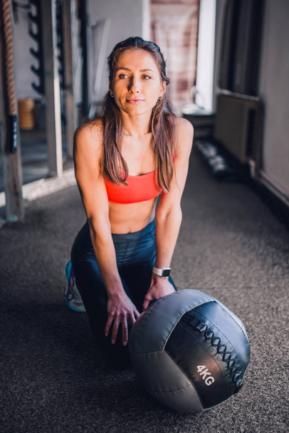 Beautiful slim athletic girl in a gym with a ball - Fotoğraf, Görsel