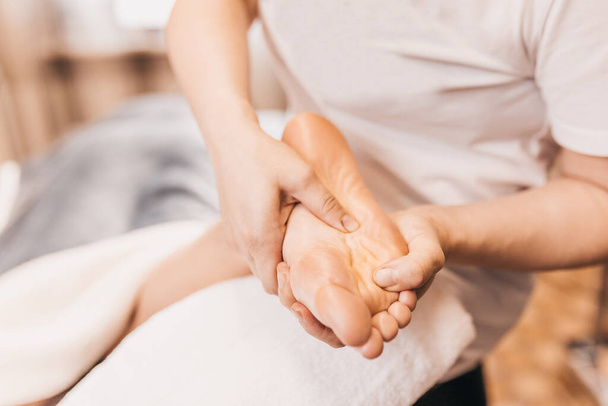 Thai foot massage - relaxing treatment - stimulation of active points of the feet - Φωτογραφία, εικόνα
