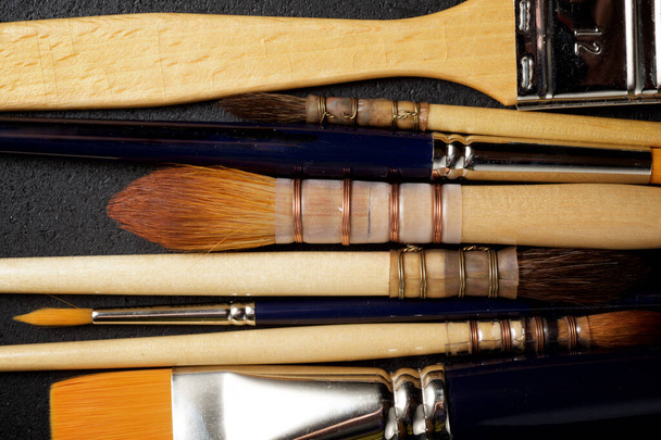 Paintbrushes on a black table. - Foto, afbeelding