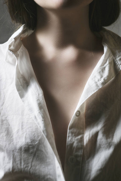 Портрет красивой модели в белой рубашке. Тонкая женская часть тела открыта. Голая шея - Фото, изображение
