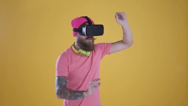 Caucasian man touch something using modern 3D vr glasses ,yellow background - Кадри, відео