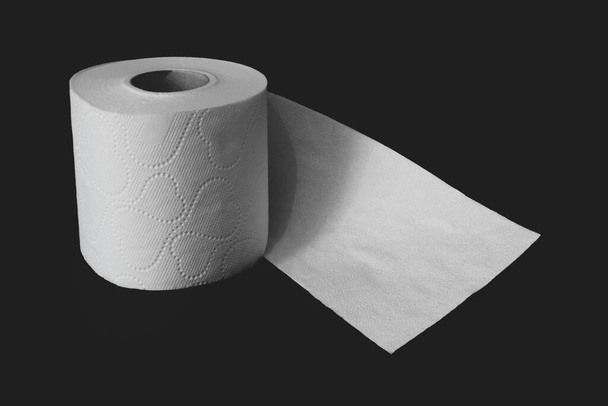 Незавернутый белый рулон туалетной бумаги на черном матовом фоне с копировальным пространством
 - Фото, изображение