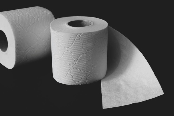 Rollos de papel higiénico blanco sin envolver sobre fondo negro mate con espacio para copiar
 - Foto, Imagen