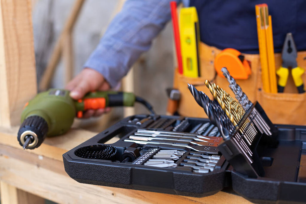 Close up picture of carpenters tool belt and work instruments on wooden background - Foto, Imagen