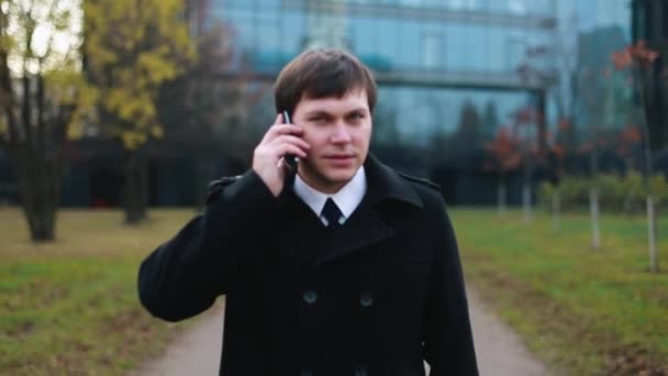 Businessman walking in the park talking on the phone - Materiaali, video