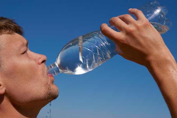 Thirst.The młody człowiek pije wody - Zdjęcie, obraz