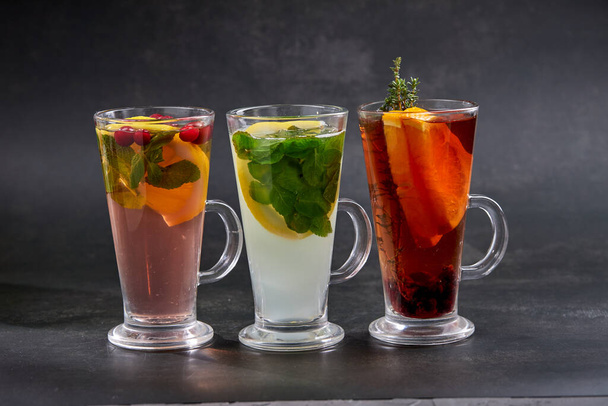 χειμωνιάτικα ποτά με βότανα και φρούτα σε ποτήρια, κοντινή θέα - Φωτογραφία, εικόνα