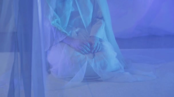 A young woman in white makes a prayer behind a white curtain - Filmagem, Vídeo