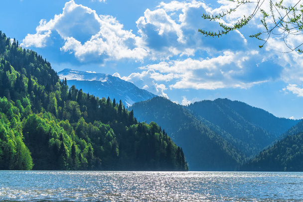 Beautiful Lake Ritsa in the Caucasus Mountains. Green mountain hills, blue sky with clouds. Spring landscape - Foto, Imagem