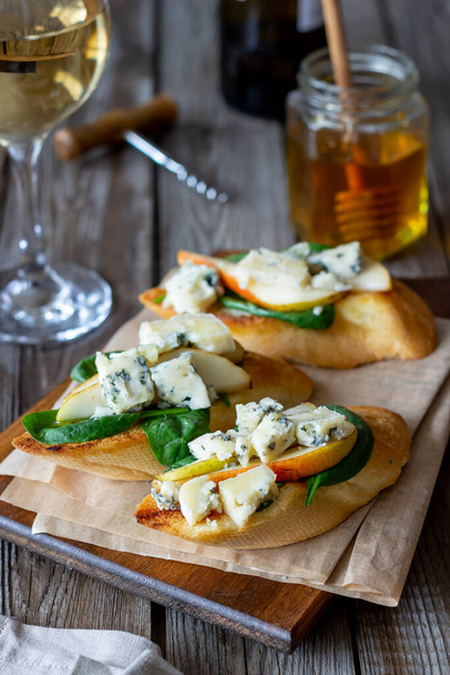 Bruschetta with spinach, pear and blue cheese. Wine. Vegetarian food. Healthy eating. Veganism Diet - Fotografie, Obrázek