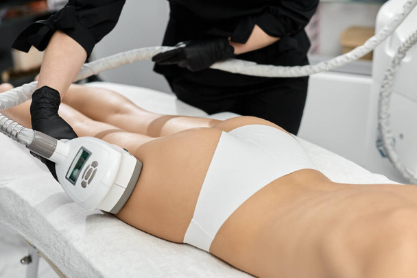 médico de beleza fazendo massagem para a perna da mulher com massageador profissional
 - Foto, Imagem