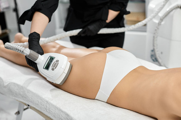 Nahaufnahme des Therapeuten, der Frau Bein mit LPG-Massagegerät massiert - Foto, Bild