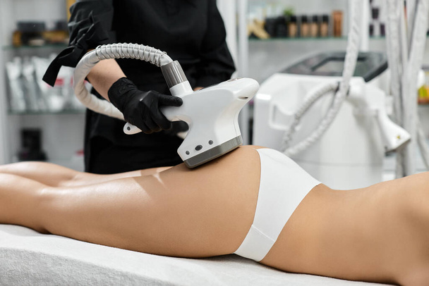 massagista profissional usando dispositivo lpg para o tratamento de bunda feminina
 - Foto, Imagem