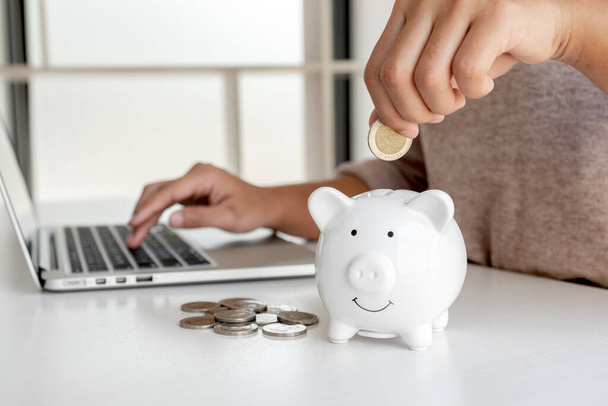 Women are putting coins in the piggy bank Saving money with coins Step into a business that is growing to be successful and save for retirement ideas. - Foto, Imagem