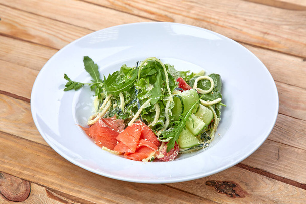 salmón salado con verduras frescas en plato blanco, vista cercana
  - Foto, Imagen