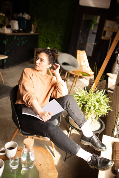 Retrato de una joven freelancer usando computadora portátil para trabajo a distancia mientras está sentada en la cafetería
. - Foto, imagen
