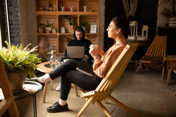 Uomo attraente e donna affascinante sta indicando lo schermo del computer portatile, lavorando e riposando al caffè con una tazza di caffè
. - Foto, immagini