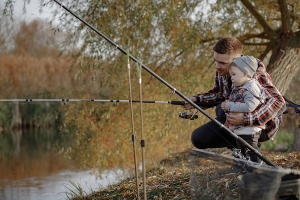 Padre con hijo pequeño cerca del río en una pesca de la mañana
 - Foto, Imagen