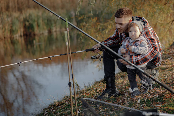 Father with little son near river in a morning fishing - Foto, Imagen