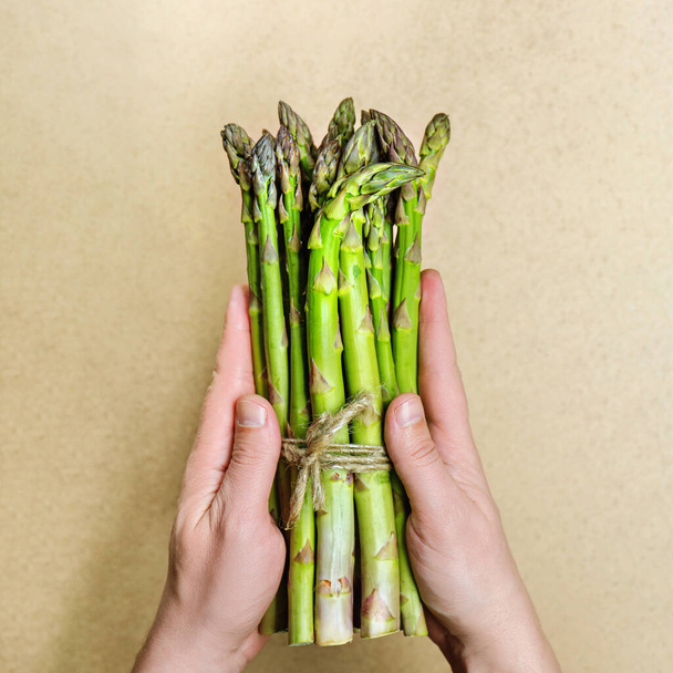 Bundle of green asparagus in male hands. - Фото, зображення
