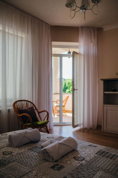 Dormitorio que se abre con puertas a una terraza con mesa de paja y sillas
. - Foto, imagen
