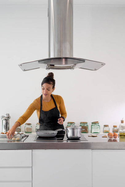 Young brunette woman frying homemade croquettes on a pan - Fotó, kép