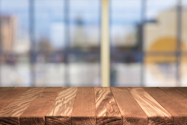 Σανίδα άδειο τραπέζι μπροστά θολή φόντο. Προοπτική καφέ ξύλο πάνω από blur σε καφενείο - μπορεί να χρησιμοποιηθεί για την επίδειξη ή μοντάζ σας προϊόντα. Χλευάσουμε επάνω σας προϊόντα. Εκλεκτής ποιότητας φίλτρο. - Φωτογραφία, εικόνα