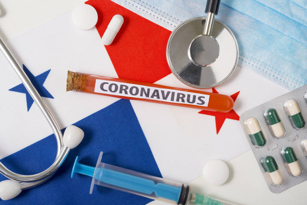 Coronavirus, nCoV έννοια. Προστατευτική μάσκα αναπνοής, στηθοσκόπιο, σύριγγα, χάπια στη σημαία του Παναμά. Ένα νέο ξέσπασμα του κινεζικού coronavirus - Φωτογραφία, εικόνα