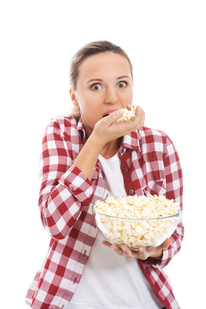 Young casual woman eating popcorn. - 写真・画像