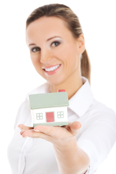 Young business woman holding a house on her palm. - Foto, imagen