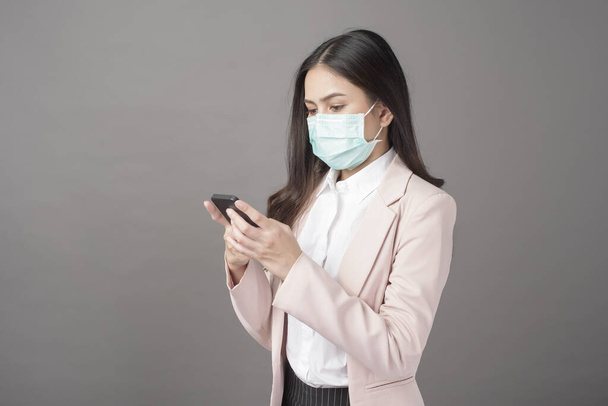Business woman with surgical mask is using cell phone  - Photo, image