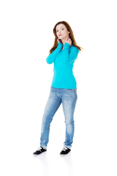 Casual woman standing and holding her neck. - Foto, afbeelding