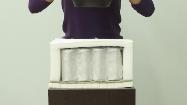 Mujer manos pone un peso pesado en un colchón de espuma ortopédica cámara lenta
 - Metraje, vídeo