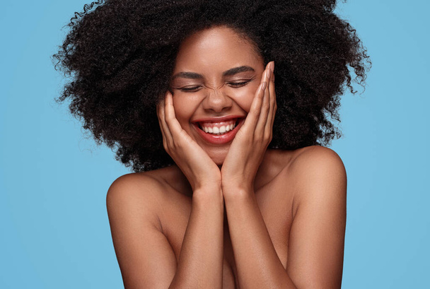 Happy African American woman with perfect skin on blue background - Фото, зображення