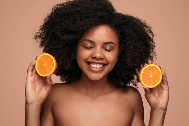Happy black woman with ripe orange - Photo, Image