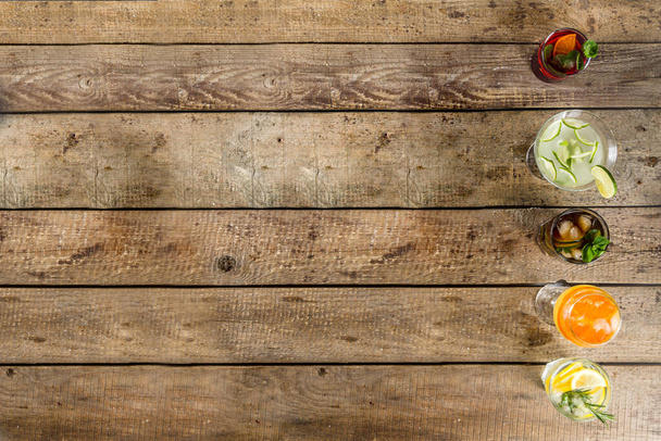 Nyári alkoholos italok választéka - álkoktélok és koktélok. Aperol spritz, Cube Libre, Gimlet martini, mojito, sangria. Különböző hideg nyári bár és party italok fa háttér másolás tér - Fotó, kép