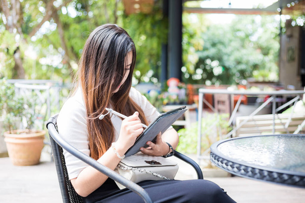 Slimme Aziatische zakenvrouwen gebruiken tablet zitten in coffeeshop outdoor - Foto, afbeelding