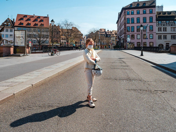 Strasbourg / France : March 27th 2020:  Quarantine time. Coronavirus epidemic. Girl on a bicycle in the empty city of Strasbourg. - Foto, afbeelding