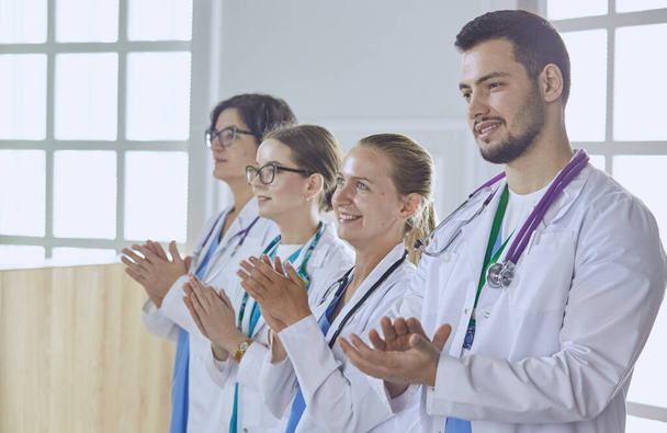 Ευτυχής ιατρική ομάδα που αποτελείται από άνδρες και γυναίκες γιατρούς χαμογελώντας ευρέως και δίνοντας τους αντίχειρες επάνω της επιτυχίας και της ελπίδας - Φωτογραφία, εικόνα