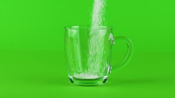 Öntsük cukor bögre üveg vastag alsó zöld kontrasztos háttér lassított felvétel - Felvétel, videó